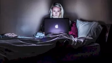 girl using laptop in bed buy now pay later 2019 plans and target government regulators